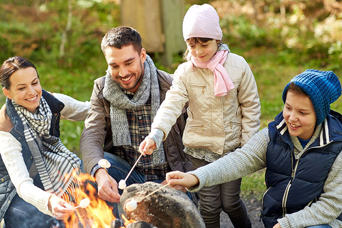 Happy Family Roasting Marshmallow over Campfire